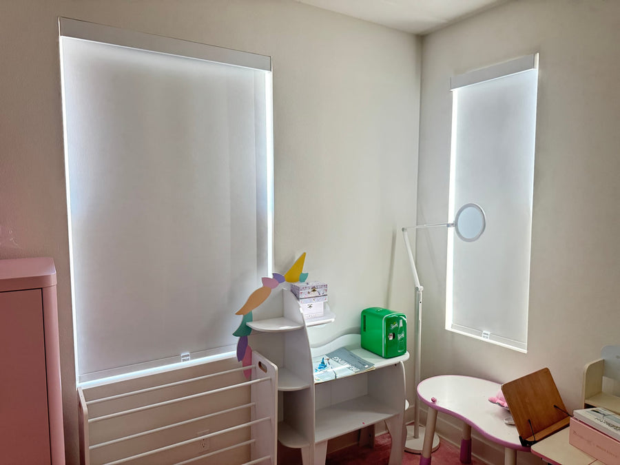 Corner bedroom with two blackout roller shades on windows of different widths