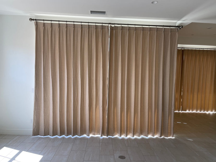 Wide drapery panels closed across a window wall on tile flooring