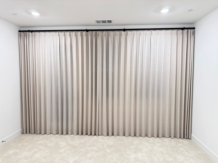 Wall-to-wall drapery panels with even pleats over a wide window wall