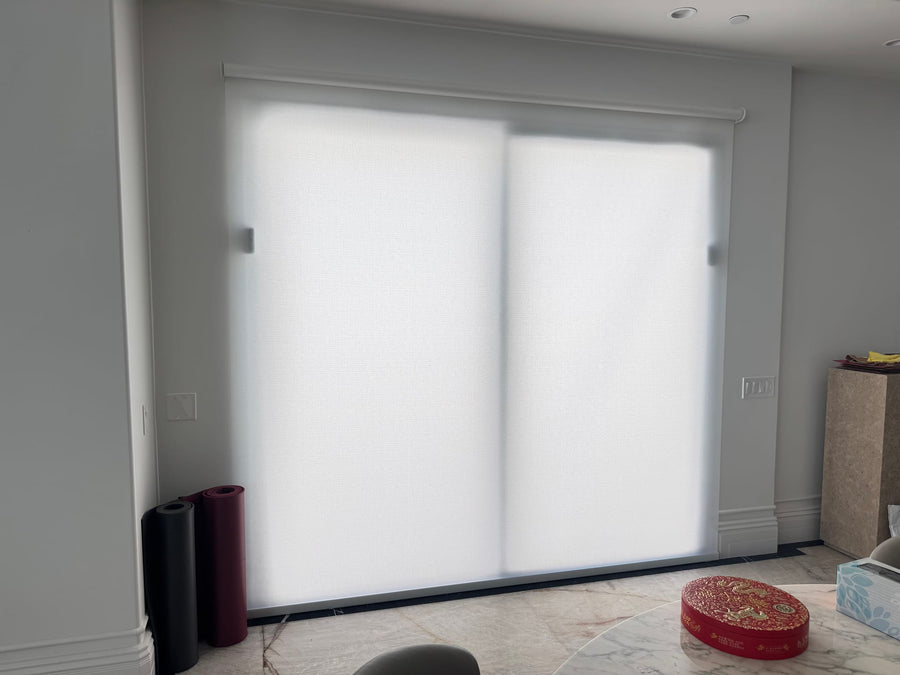 Wide Designer Roller shade covering a sliding glass door in the adjoining dining area