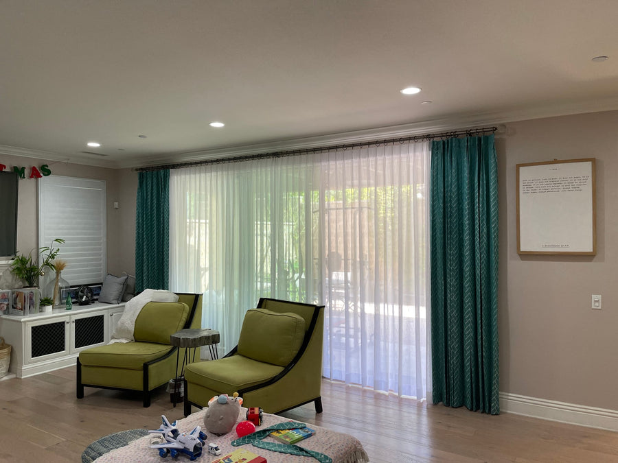 Adjacent living area with matching sheers and teal drapery on a wide slider