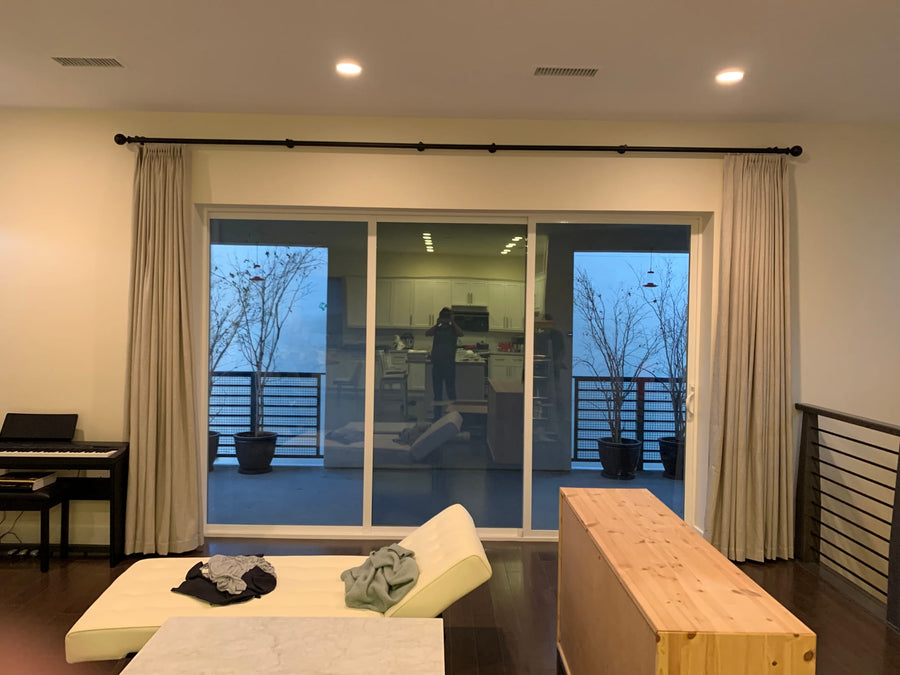 Drapery stacked at both sides of a sliding glass door in the living room