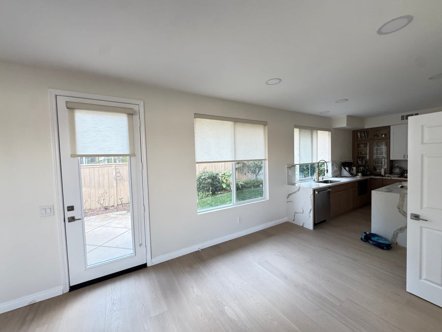 Designer Roller shades on the patio door and kitchen windows in an open dining area