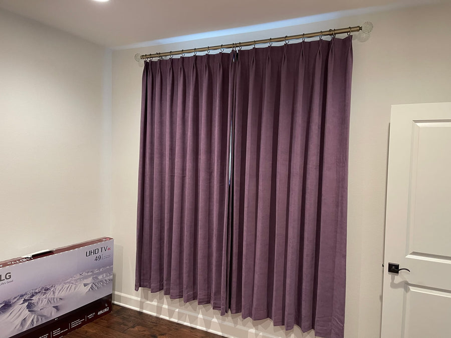 Plum velvet panels drawn closed across a bedroom window