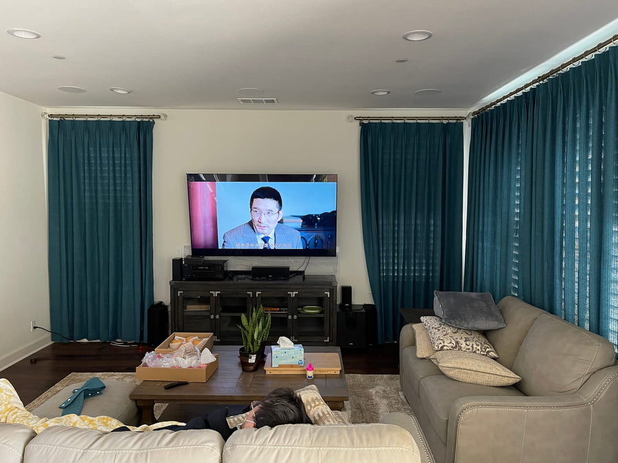 Living room with teal panels on three window walls