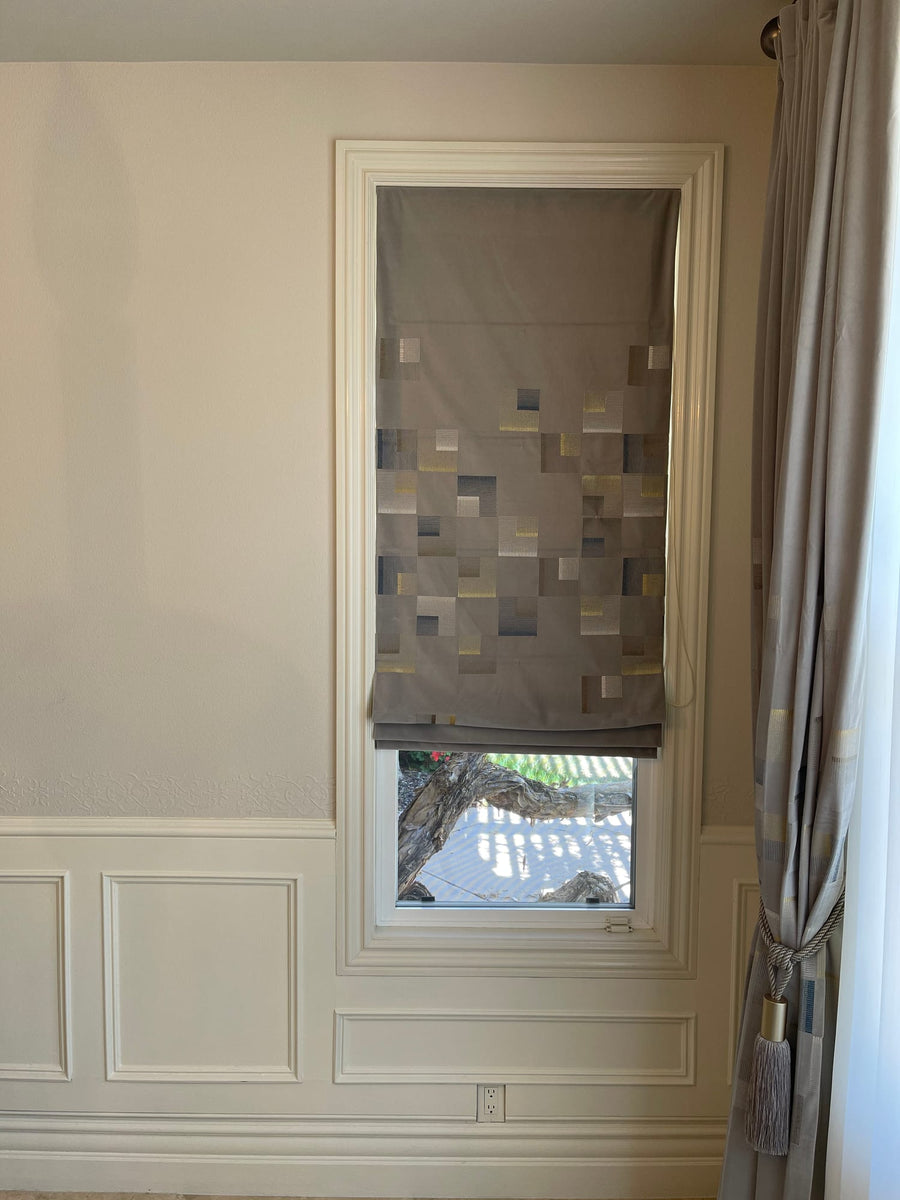Vignette shade raised above a tall narrow window with panelled wainscoting and a drapery panel